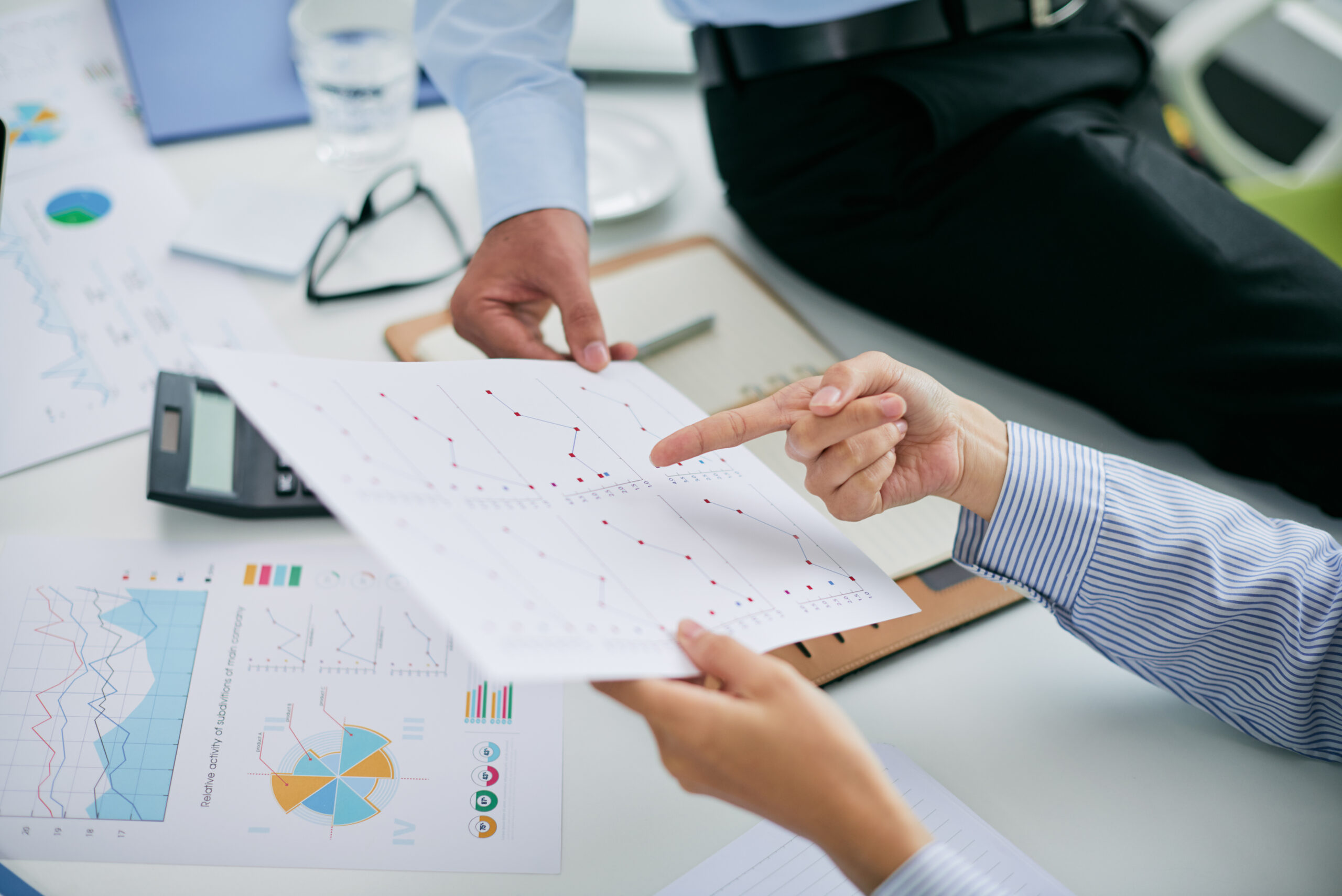 Hands of financial managers pointing at document